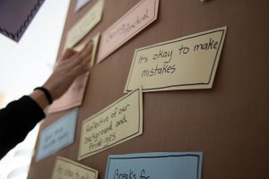 Erilaisia lappuja kiinnitettynä taululle, etualalla olevassa lapussa lukee ”It’s okay to make mistakes”.