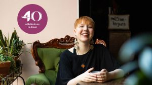 Valo Vesikauris hymyilee kameralle istuessaan vihreällä tuolilla.