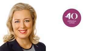 Jutta Urpilainen hymyilee kameralle.