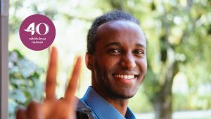 Liban Sheikh hymyilee kameralle tehden voitonmerkin kädellään.