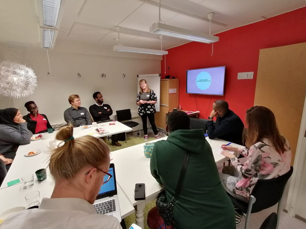 Toiveista totta työpajassa istutaan pöytien ääressä, tehdään muistiinpanoja ja seurataan puhujaa ja hänen slide-esitystä.
